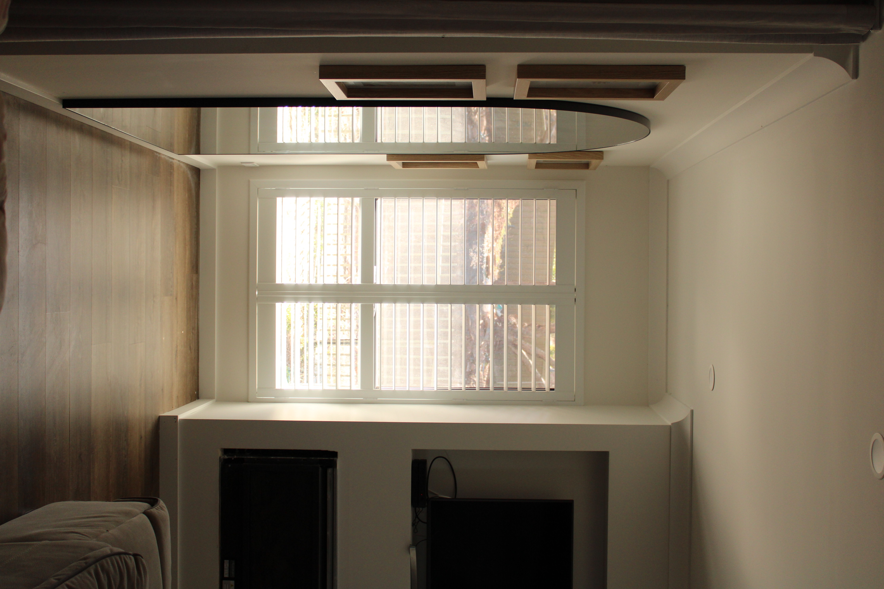 Plantation shutters angled to keep afternoon sun off a living room floor