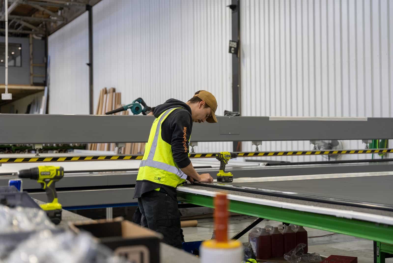 DHE staff member working along the assembly line at the Elizabeth South factory