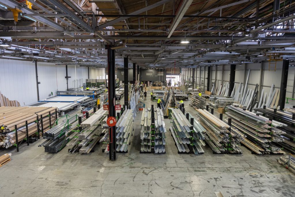 DHE's Elizabeth South factory floor from above, with racks of aluminium profiles and staff at the work benches