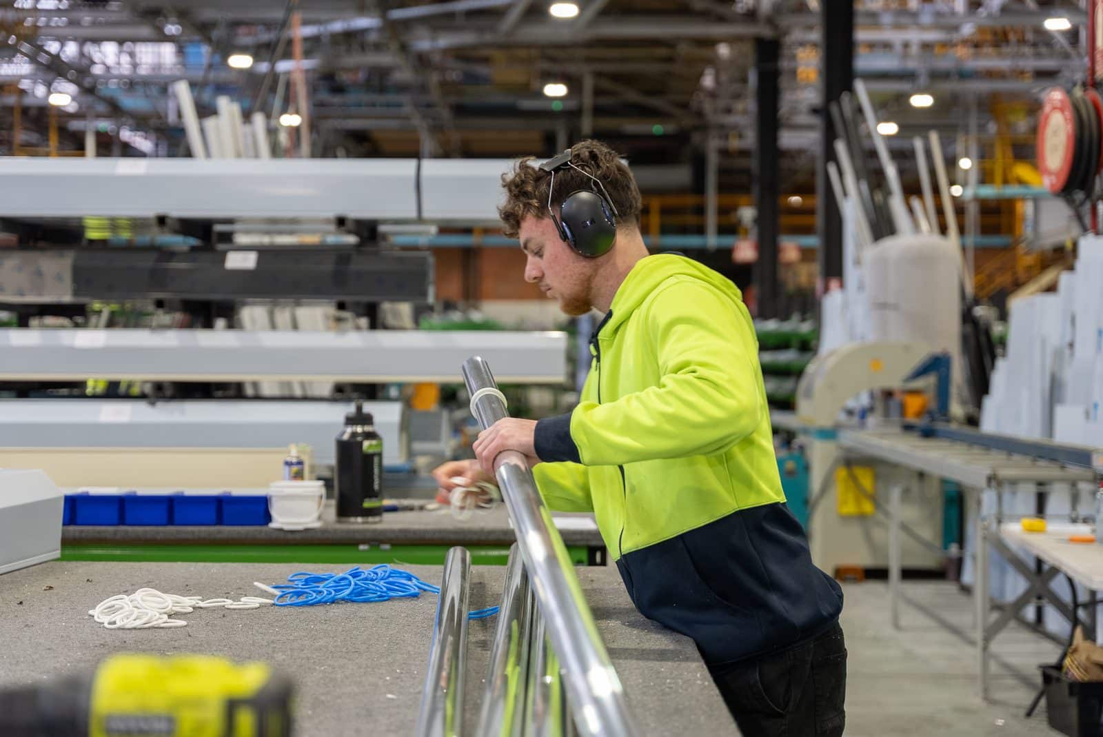 DHE team member in hi-vis assembling a component on the factory floor