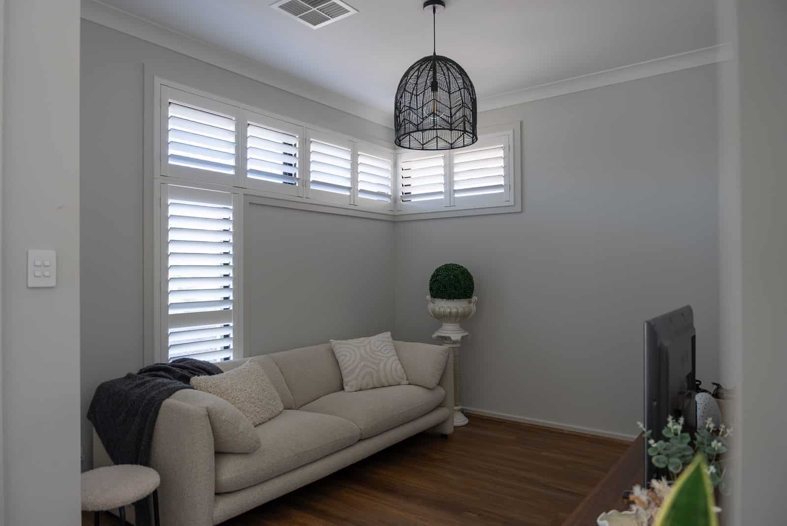 Plantation shutters in a lounge room with sofa and timber floor