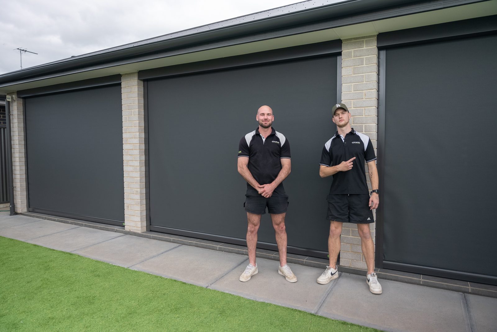 Two DHE team members in front of a completed outdoor blind installation