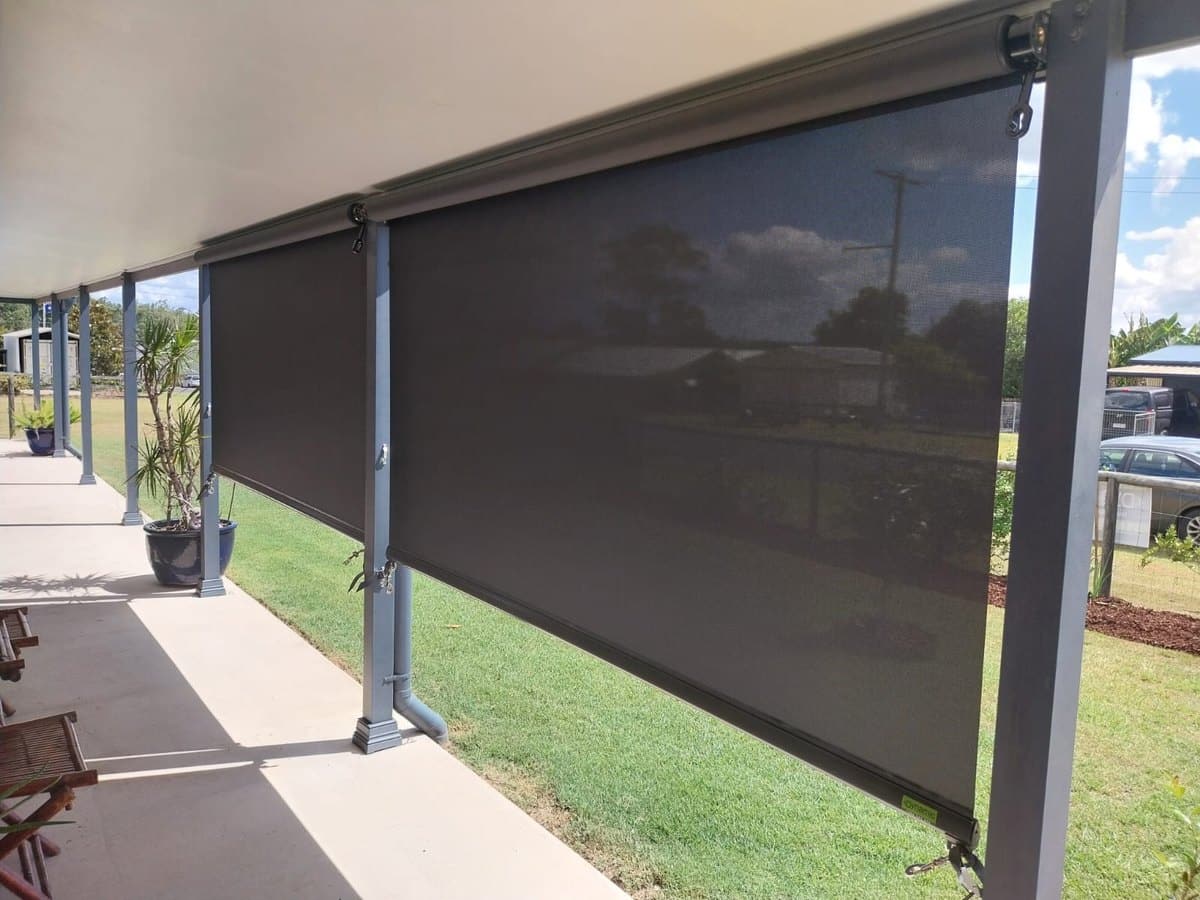 Charcoal straight drop outdoor blinds hanging from a verandah beam with no side guide rails
